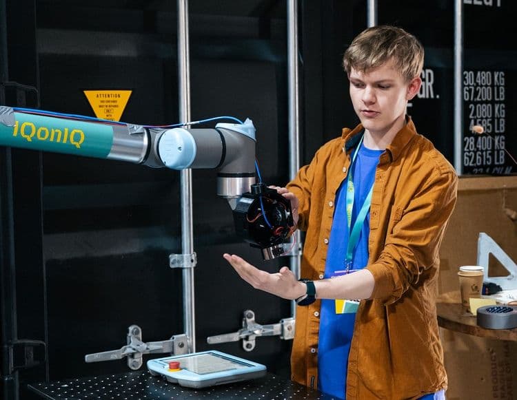 Jongeman bij robotarm